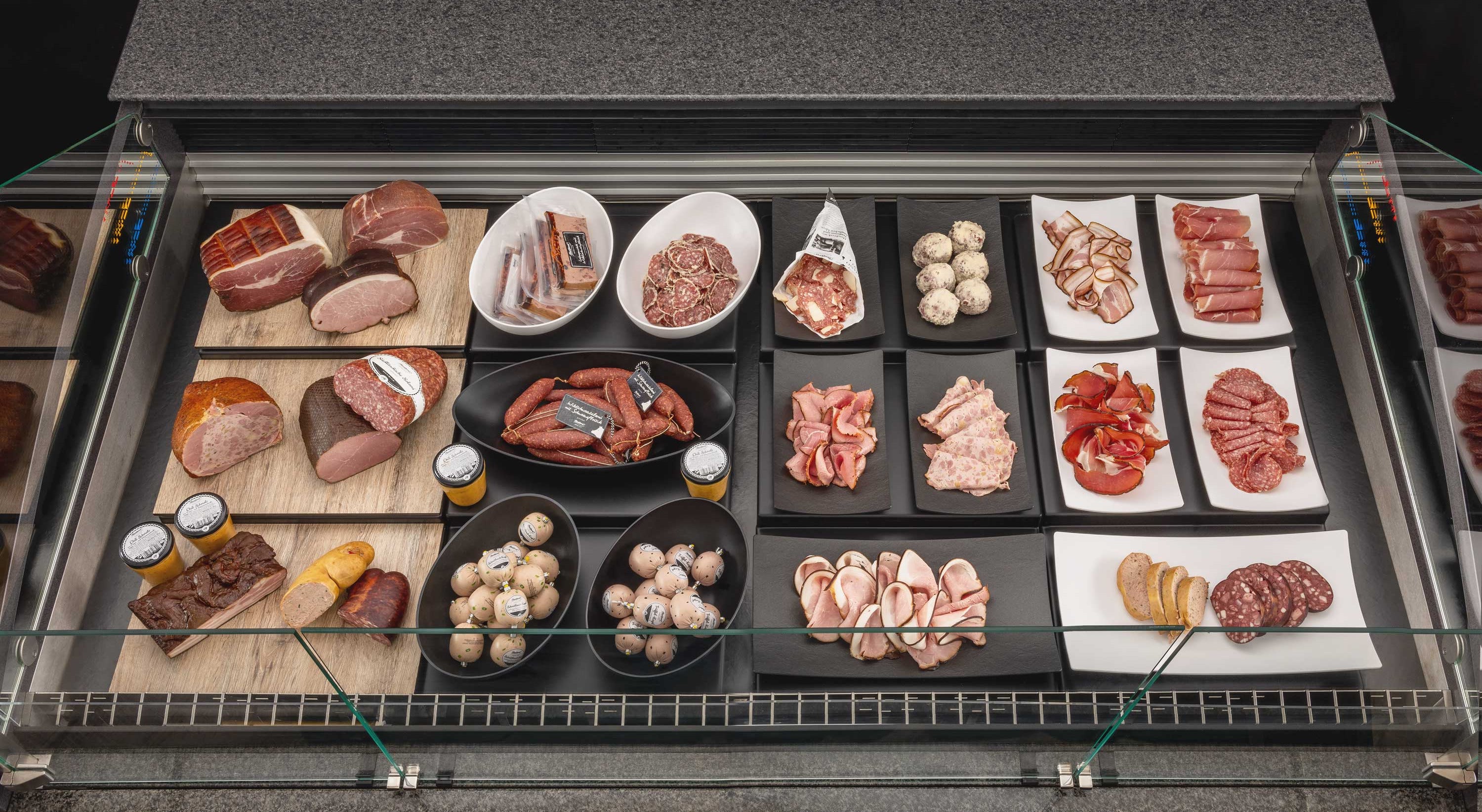 Wursttheke mit schwarzen und weißen Thekenschalen